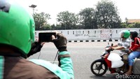 Seorang warga memotret coretan-coretan yang terlihat di area sekitar depan gedung DPR, Jakarta, usai aksi demo yang dilakukan oleh massa pada Senin (23/9) lalu. Seorang warga memotret coretan-coretan yang terlihat di area sekitar depan gedung DPR, Jakarta, usai aksi demo yang dilakukan oleh massa pada Senin (23/9) lalu.