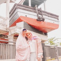Tampil dengan hijab motif dan busana serba pastel, Awkarin berpose dengan seorang ibu asli Aceh yang pernah mengalami bencana Tsunami. Keduanya berpose di kawasan wisata Kapal di Atas Rumah. Foto: Dok. Instagram @awkarin