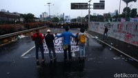 Mahasiswa yang terkena air pun lari ke berbagai arah. Meski demikian, para mahasiswa ini kemudian berbalik dan melempari aparat dengan botol hingga batu.