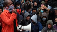Beberapa orang bergantian menyuarakan aspirasinya menggunakan pengeras suara. 