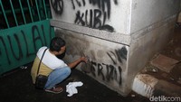 Vandalisme yang terlihat di depan gedung DPR langsung dihapus menggunakan tinner.