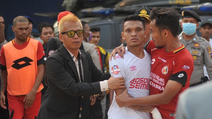 Pesepak bola Semen Padang FC, Muhammad Rifqi (kanan) berusaha menenangkan pemain PSM Makassar, Ferdinand Sinaga (tengah) akibat insiden cederanya kiper Rivky Mokodompit, pada pertandingan lanjutan putaran kedua, Liga 1, di Stadion GOR H Agus Salim Padang, Sumatera Barat, Senin (23/9/2019). Semen Padang FC berhasil mengalahkan PSM Makassar dengan skor 2-1. ANTARA FOTO/Iggoy el Fitra/foc.