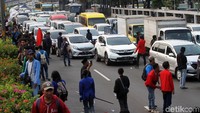 Para mahasiswa menghalangi lalu lintas kendaraan di tol dalam kota.