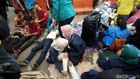 Nampak sejumlah mahasiswa berbaring di salah satu sisi jalan karena kelelahan saat mengikuti aksi demo di depan gedung DPR, Jakarta.