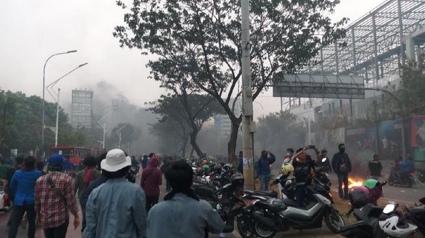 Pembakaran banner dan barrier menimbulkan asap pekat.