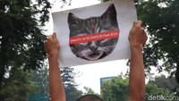 Spanduk dengan gambar kucing yang ditutup matanya dengan tulisan, Wkatu Kita Diatur Bos juga ikut dipajang.