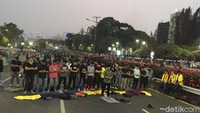 Mereka menunaikan salat di tengah aksi demonstrasi yang masih berlangsung.
