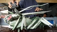 Seorang warga tengah membersihkan salah satu kerajinan kayu yang berada di toko oleh-oleh tersebut.