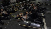 Kondisi depan Gedung DPR yang mulai kondusif kini menjadi tempat beristirahat sejumlah petugas kepolisian.