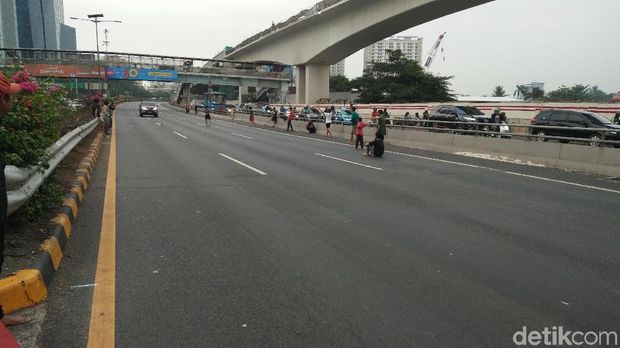 Bocah asyik main bola di tol dalam kota Cawang arah Pancoran, Rabu (25/9/2019)