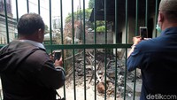 Beberapa warga mencoba mengabadikan sisa kebakaran pos polisi.