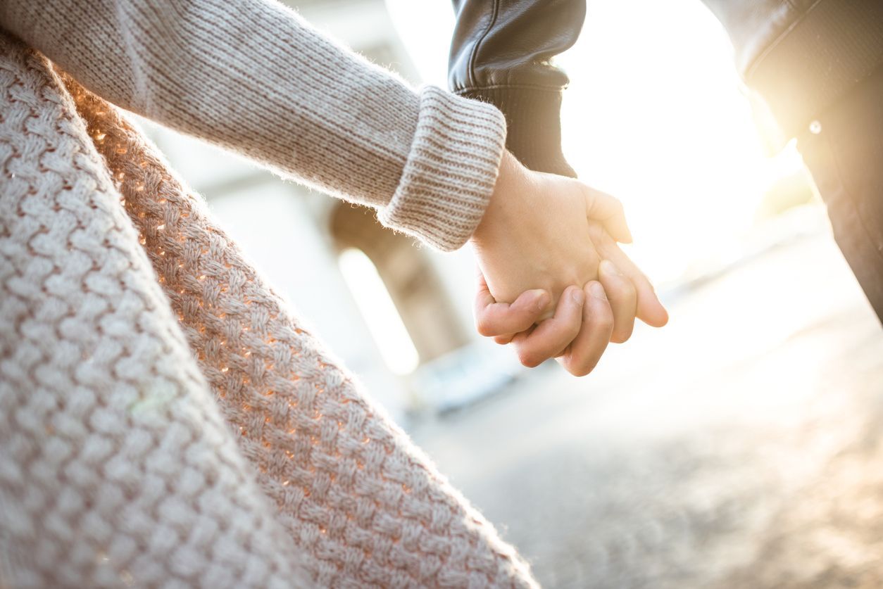Close up of couple holding hands reconciled after quarrel, happy and relaxed about saved marriage. Husband and wife making peace avoiding break up. Concept of preserved relationship, family support