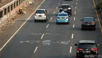Seorang petugas kebersihan menyisir pinggir tol dalam kota untuk membersihkan sampah sisa demo.