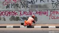 Petugas PPSU tengah membersihkan coretan-coretan pascademo mahasiswa di kawasan Flyover Senayan, Jakarta, Rabu (25/9/2019).