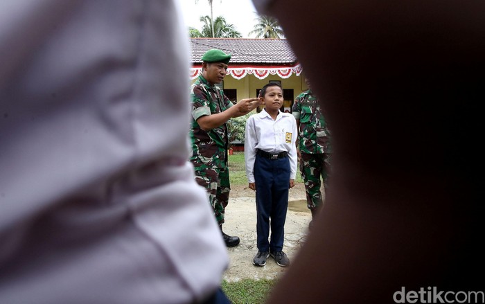 Sejumlah siswa SMP di Pulau Simeulue, Aceh, berbaris rapi dengan posisi sikap sempurna. Mereka mengikuti latihan baris berbaris yang diberikan oleh anggota TNI.