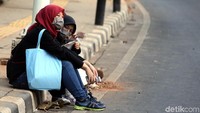 Dua orang pegawai kantor beristirahat di trotoar usai berjalan pulang dari kantornya di kawasan Senayan.Aksi demo kelompok massa siswa STM dari sejumlah sekolah berujung ricuh di belakang Gedung DPR RI, Jakarta, Para pegawai pun harus berjalan kaki, Rabu (25/09/2019).