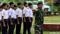 Seorang anggota TNI AD menunjukkan satu per satu posisi dalam pelatihan baris berbaris (PBB) di depan sejumlah siswa.