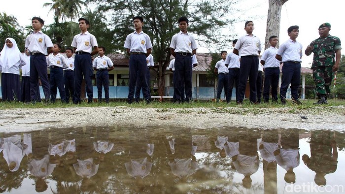 Sejumlah siswa SMP di Pulau Simeulue, Aceh, berbaris rapi dengan posisi sikap sempurna. Mereka mengikuti latihan baris berbaris yang diberikan oleh anggota TNI.