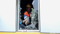 Petugas membersihkan pecahan kaca gardu di gerbang tol Pejompongan.