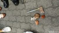 Polisi mengamankan kapak dan batu yang dilempar massa.