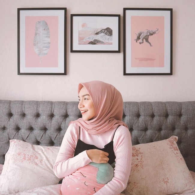 Sesekali Melody Prima memakai hijab pashmina simpel dengan satu jarum pentul. Seperti pada foto ini ia memakai pashmina hitam bahan ceruti yang ia sampirkan satu sisi ke belakang. Foto: instagram @melodyprima