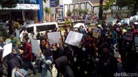Sepanjang jalan suara nyanyian mereka menggema. Kendaraan polisi berjaga dengan mengawal aksi.