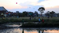 Mereka bermain di area tambak yang mengering akibat kemarau.