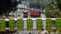 Dua mobil Dinas Kebersihan DKI Jakarta nampak masih membersihkan jalan itu.