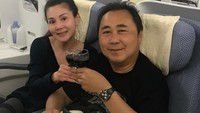 A glass of wine before we sleep, tulis Margaret pada unggahan foto ini. Di sini ia dan sang suami menikmati segelas wine saat melakukan perjalanan dengan pesawat. Foto: instagram @margaret vivi