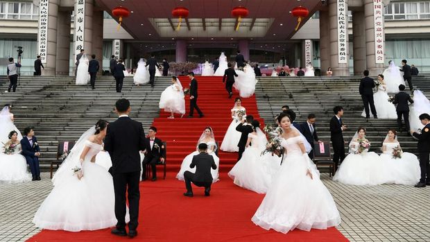 Couples attend a mass wedding at the city's municipal government building ahead of the 70th founding anniversary of People's Republic of China in Jiaxing, Zhejiang province, China September 22, 2019. REUTERS/Stringer ATTENTION EDITORS - THIS IMAGE WAS PROVIDED BY A THIRD PARTY. CHINA OUT.     TPX IMAGES OF THE DAY