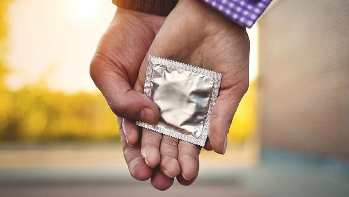 Men, women, couples Holding a condom for self-protection. Concept to prevent contraception.