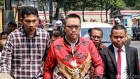Imam nampak mengenakan kemeja putih yang dibalut dengan jaket bermotif batik berwarna merah.