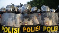 Polisi dengan tameng dan helm siaga di depan gedung DPR.