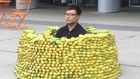 Kalau pria ini sepertinya pencinta berat pisang. Ia rela duduk dikelilingi susunan ratusan pisang. Foto: Istimewa
