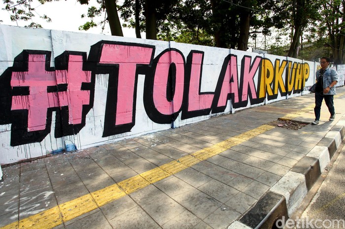 Ada pemandangan menarik saat melintasi Jalan Pemuda, Rawamangun, Jakarta Timur. Mural menolak RKUHP menghiasi dinding jalan itu.
