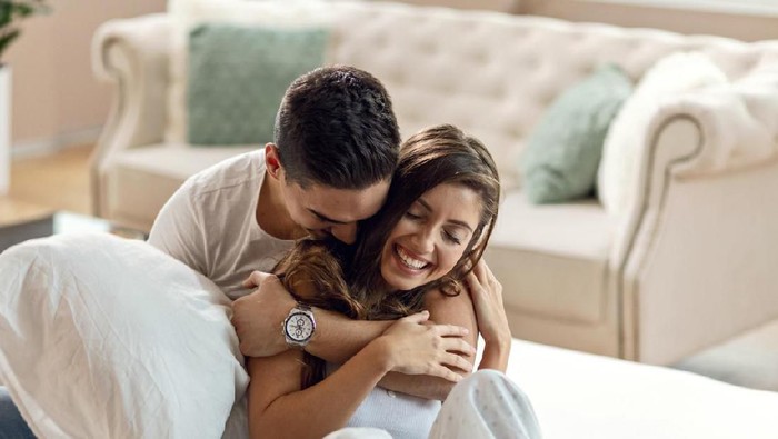 Young beautiful and happy couple man and woman at home in bedroom in bed romantic and in love