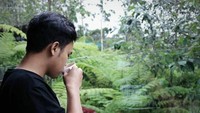 Berpose sambil meminum secangkir teh dengan pemandangan pepohonan, Dinno tuliskan caption romantis, Dek sini ngeteh sama abang, kira-kira untuk siapa ya? Foto: Instagram @dinnoardiansyah