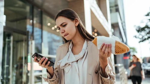The busy businesswoman working online on a smartphone during a break