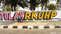 Mural bertuliskan #TolakRKUHP itu diwarnai dengan warna merah muda dan kuning sehingga menarik perhatian para pengguna jalan di kawasan tersebut.