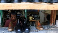 Seorang perajin alas kaki nampak sibuk menyelesaikan pembuatan sandal di rumah produksi sepatu Cibaduyut yang berada di Kecamatan Bojongloa Kidul, Kota Bandung.