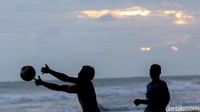 Anak-anak tersebut dibagi menjadi dua kelompok saat bermain bola di pinggir pantai.