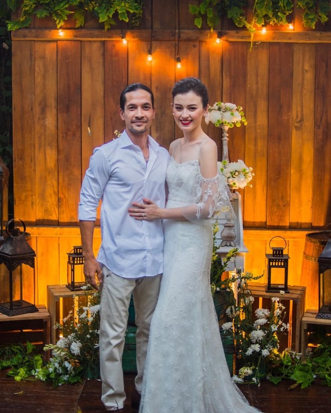 Menikah secara sederhana, pasangan artis Kimberly Ryder dan Edward Akbar juga mengusung gaya serupa untuk pesta pernikahan mereka. Dekorasi pernikahan Kimberly dan Edward pun dibuat minimalis dengan tema rustic vintage. Tampak penggunaan kayu sebagai latar area pelaminan ditambah lampu-lampu yang diletakkan di atas kotak kayu. Foto: Instagram
