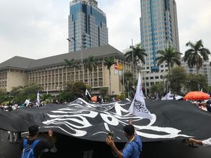 Massa Aksi Mujahid 212 Bentangkan Bendera Tauhid Raksasa di Patung Kuda