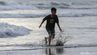 Seorang anak di Pulau Simeulue, Aceh, bermain bola di pinggir pantai.