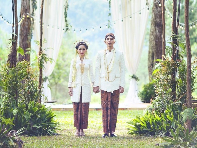 Andien mengenakan kebaya Jawa klasik rancangan Didiet Maulana saat akad nikah pada 2015. Kebaya berbahan lace itu dilengkapi ronce melati yang menambah kesan tradisional. Untuk kainnya, ia memakai kain batik Wahyu Temurun. Foto: Dok. JAYSU Weddings by Jacky Suharto