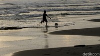 Bermain bola di pinggir pantai ini jadi salah satu aktivitas yang kerap dilakukan anak-anak tersebut di kala sore tiba.
