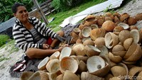 Dua orang warga Miangas tengah mengolah ratusan buah kelapa tua untuk dijadikan kopra.