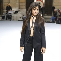 Camila Cabello tampil dengan power suit alias setelah blazer dan celana serba hitam di momen pertamanya sebagai model catwalk. Camila terlihat seksi karena dia tidak mengenakan apapun di balik blazernya. Foto: Vianney Le Caer/Invision/AP