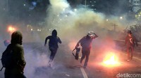 Mereka bertahan dari kepulan asap gas air mata.