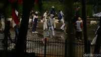 Berhasil dipukul mundur, beberapa dari massa aksi tetap melemparkan batu ke arah petugas.